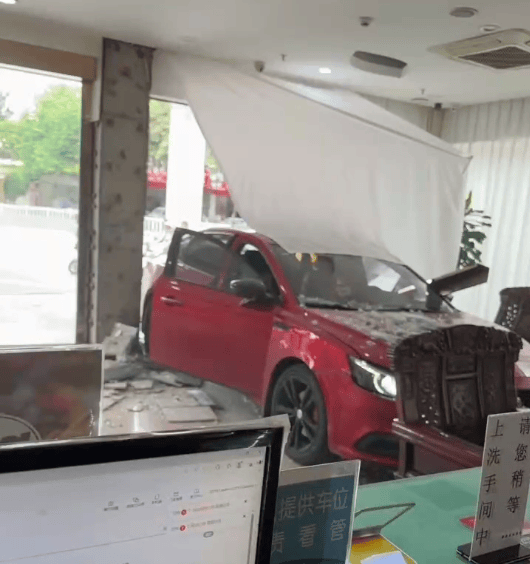 红色小车撞碎酒店玻璃墙冲进大堂， 两男子沙发上跑开躲过一劫；知情人：女司机误把油门当刹车踩