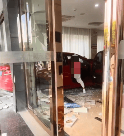 红色小车撞碎酒店玻璃墙冲进大堂， 两男子沙发上跑开躲过一劫；知情人：女司机误把油门当刹车踩